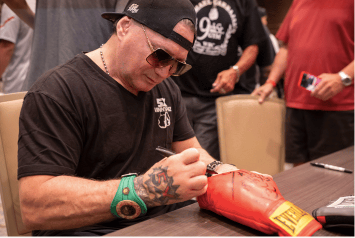 Vinny Paz signs an autograph.