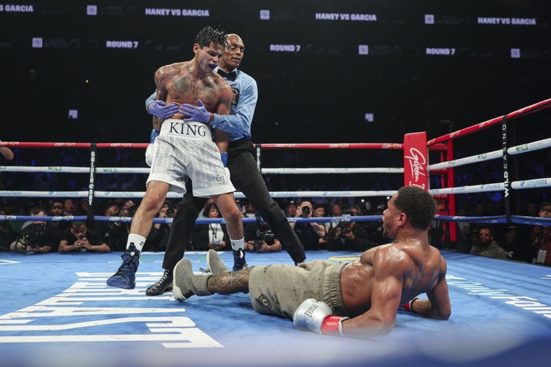 Referee Harvey Dock moves Ryan Garcia away after the third knockdown of Devin Haney in round 11. Photo: Cris Esqueda, Golden Boy Boxing